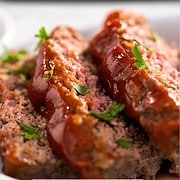 spicy cajun meatloaf sliced and garnished with chopped parsley on a serving platter