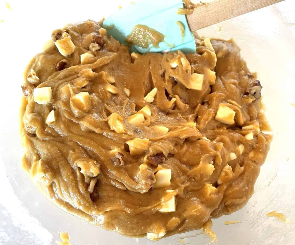 mixing batter for blondies with white chocolate chunks and chopped walnuts