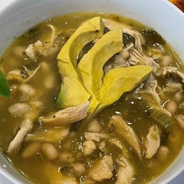 chicken chili verde topped with sliced avocado and with a side of corn casserole