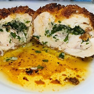 chicken kiev sliced open with parsley butter spilling out