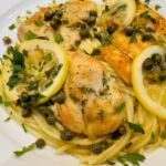lemon chicken piccata over spaghetti with capers and lemon slices