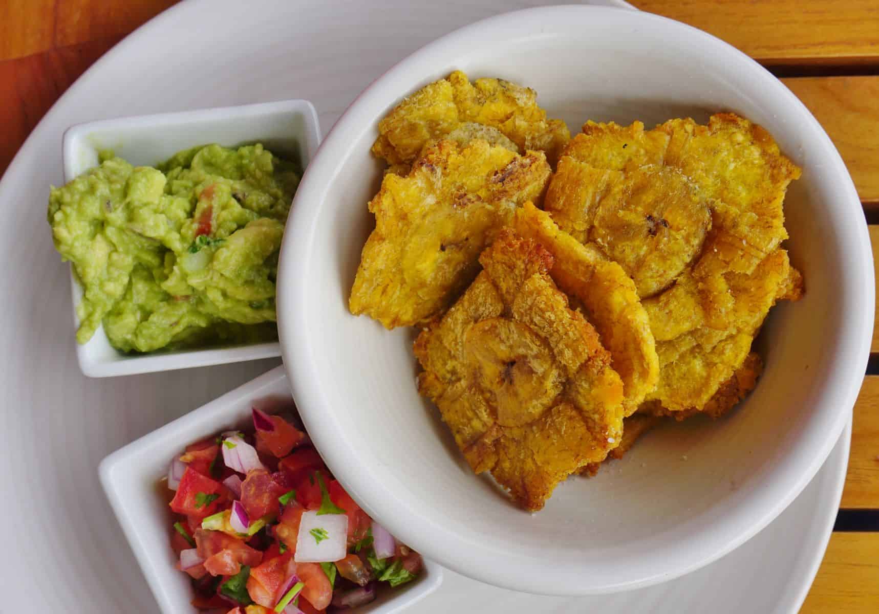 patacones on a plate with guacamole and salsa