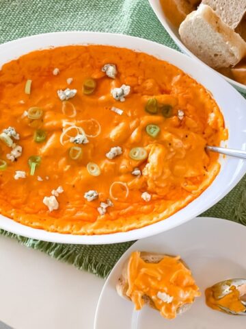 buffalo chicken dip in a baking dish with bread for serving