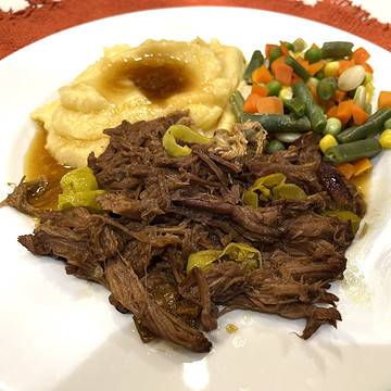 mississippi pot roast on a plate with mashed potatoes and mixed vegetables