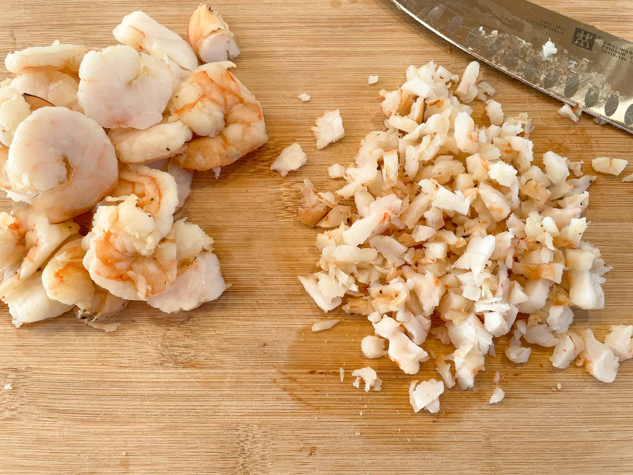 cooked shrimp being chopped into a find dice