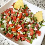 fresh salsa of tomato, jalapeno, garlic, onion, cilantro and lime juice in a bowl in tortilla chips