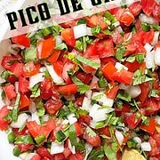 Tomato, onion, cilantro, jalapeno and lime chopped and combined in a white bowl to make pico de gallo