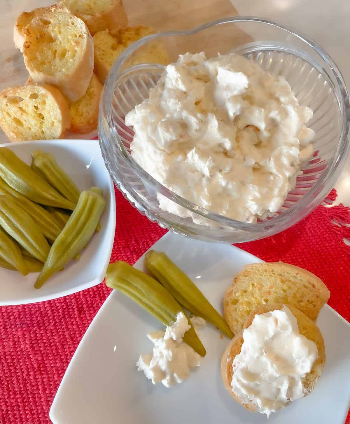 cold shrimp dip made with cream cheese and sour cream in a bowl served with pickled okra and garlic bread