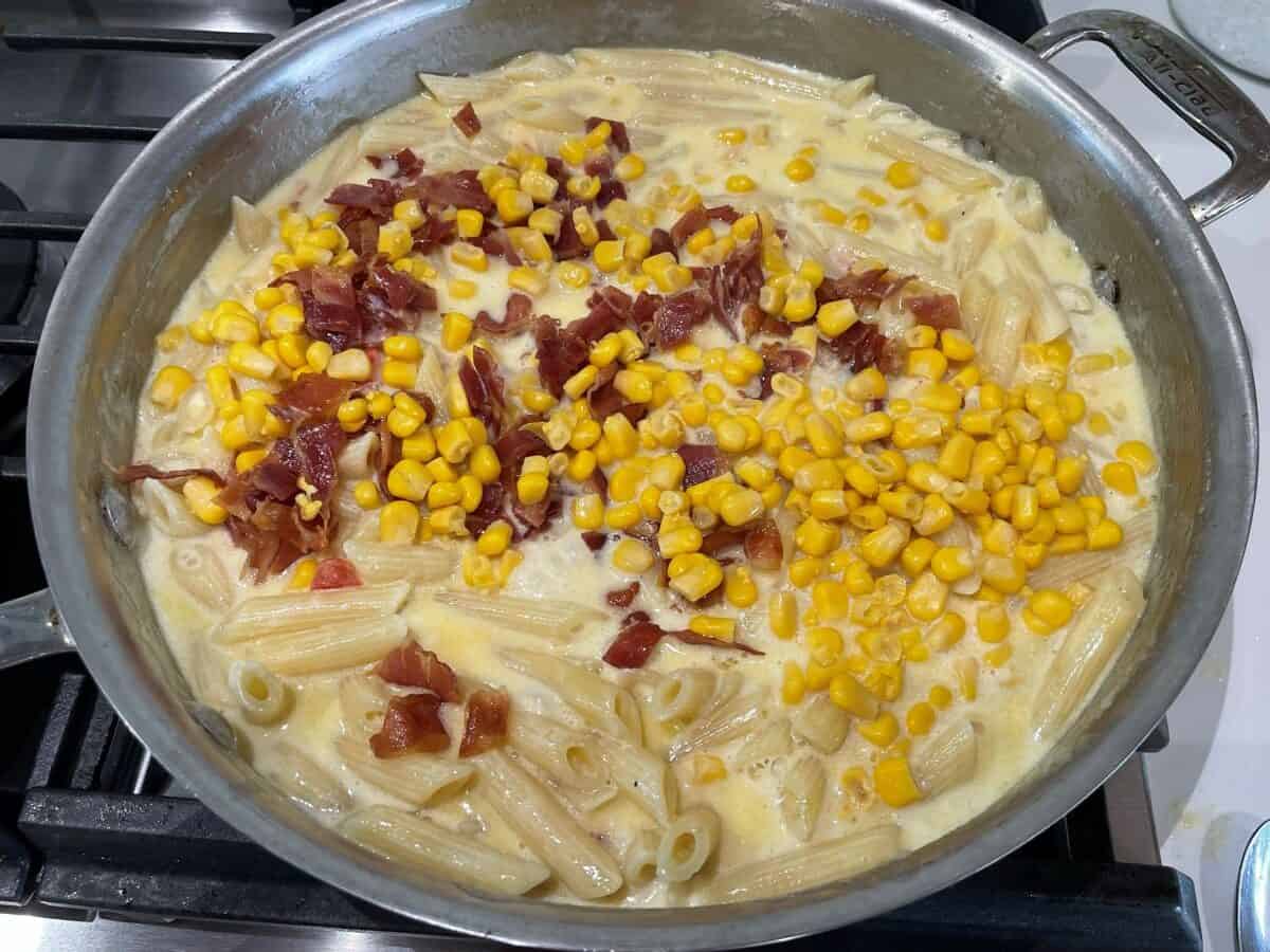 alfredo sauce with penne pasta corn bacon and chipotle paste simmering