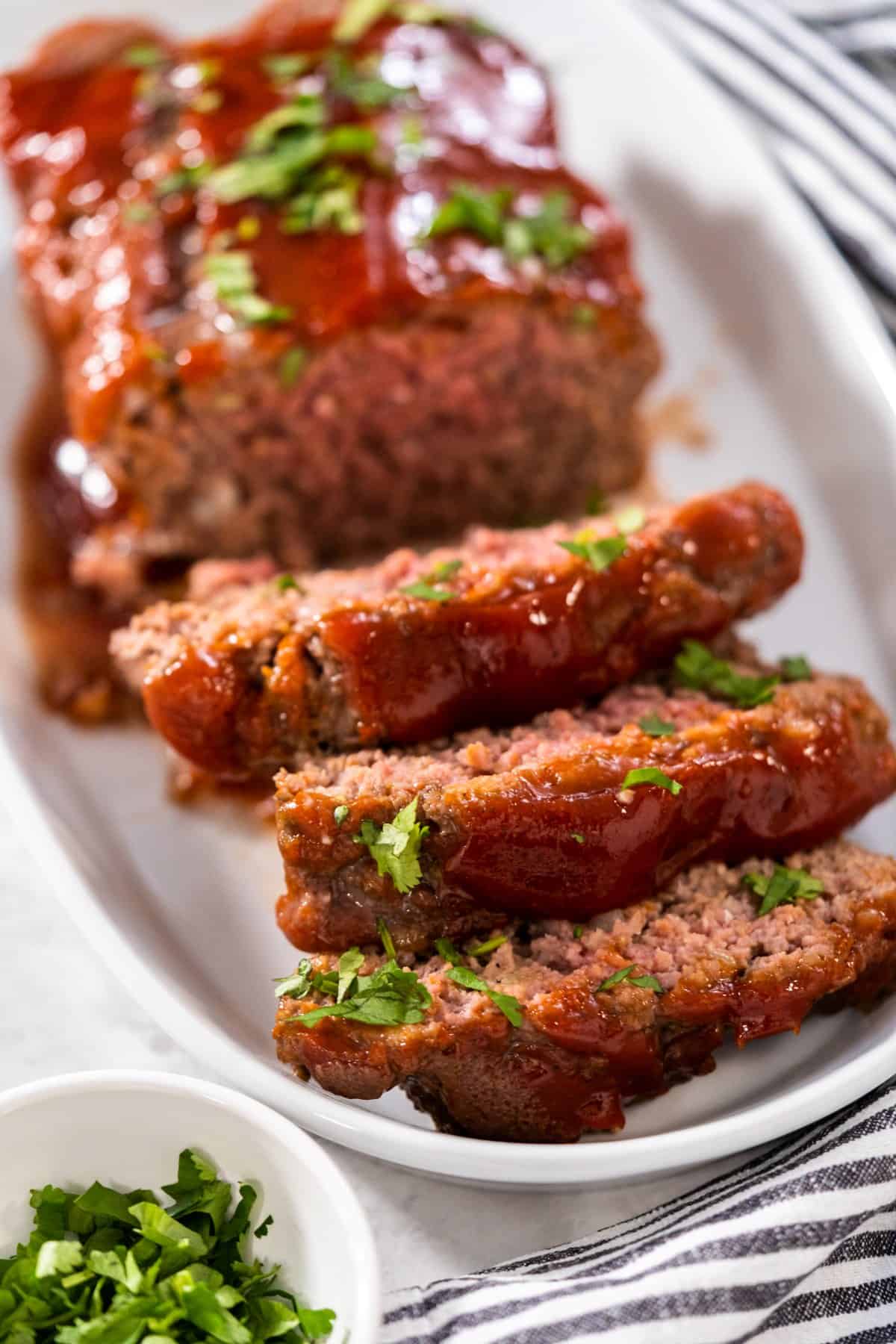 paul prudhomme meatloaf with a glaze garnished with parsley and served on a platter