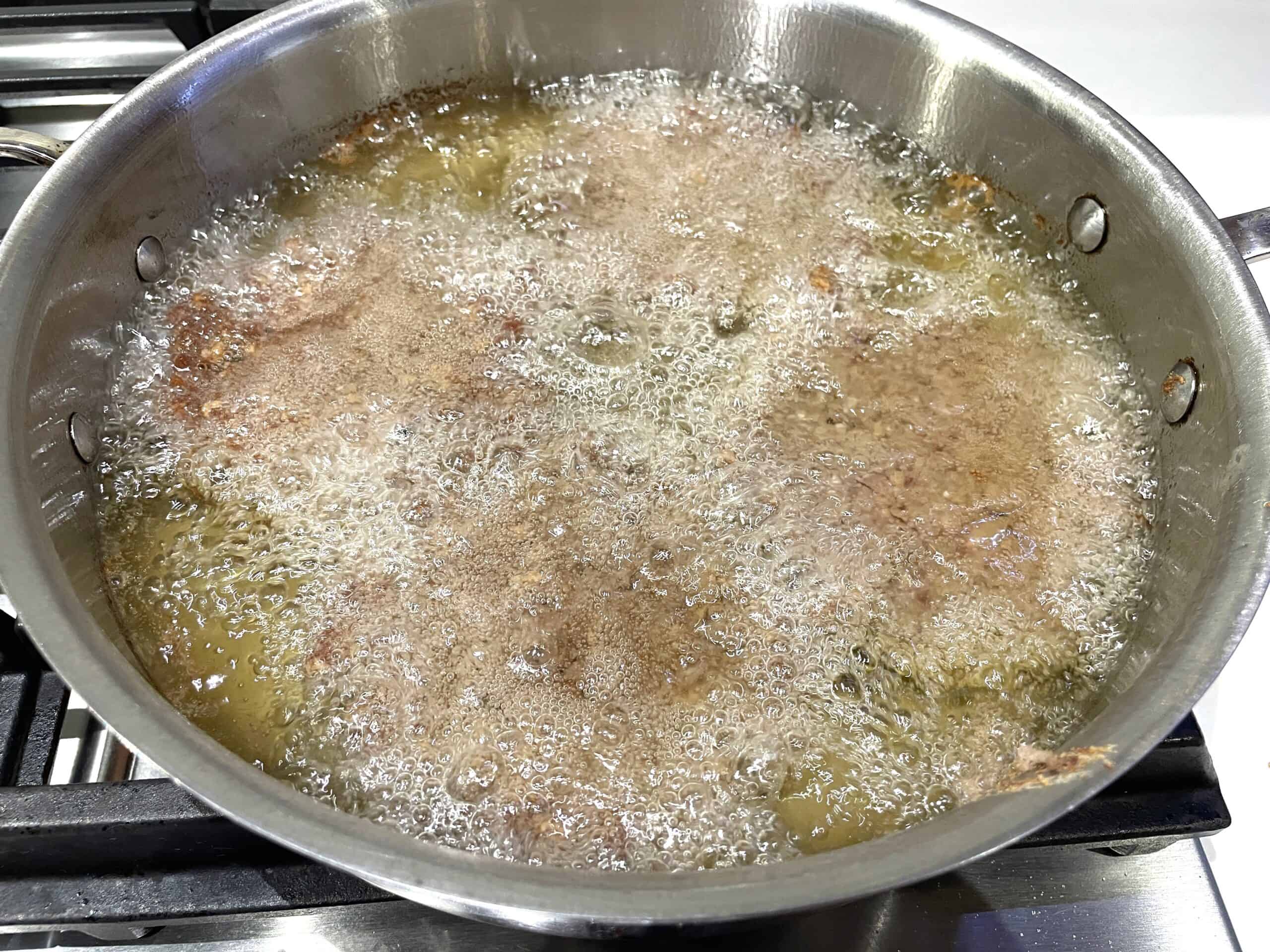 slugburgers deep frying in a pan